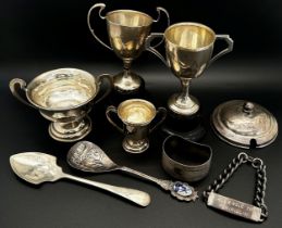 Four small silver trophies, a silver jar lid, two silver spoons, a napkin ring and a bracelet, 8