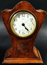 An Edwardian mahogany mantle clock with shaped outline, chequered string borders and eight day