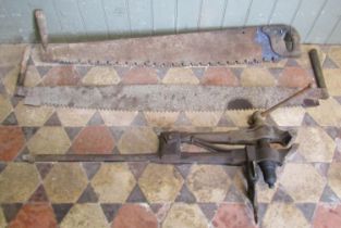 A vintage heavy cast iron leg vice together with 2 two man tree felling saws (3) (af)