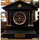 A Victorian black slate mantle clock with column supports and eight day time piece, brass