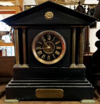 A Victorian black slate mantle clock with column supports and eight day time piece, brass