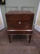 A Georgian mahogany box on stand, the rising lid revealing a segmented interior set on an open