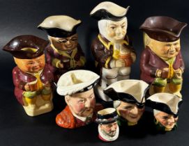 A collection of Royal Doulton and other Toby jugs in various sizes, including Veteran Motorist,