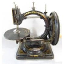 A scarce Nussey & Pilling 'Little Stranger' Victorian sewing machine with gilt decoration, on metal