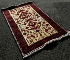 North East Persian Meshed Belouch Rug with an all over stylised animal and flower design on a