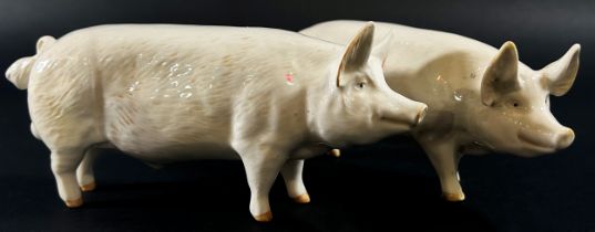 A collection of Beswick porcelain animals to include two pigs, a ewe and three lambs