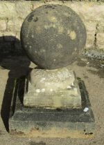 A weathered cast composition stone square stepped pier cap with ball finial, 32 cm square x 46 cm