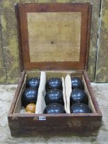 A cased set of lawn bowls, 8 large balls in ebony together with two smaller boxwood examples