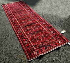 North West Persian Malayer Runner with a central panel with a repeating geometric pattern on a red