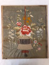 A 19th century needlework, depicting a hanging basket of flowers with surrounding floral decoration,