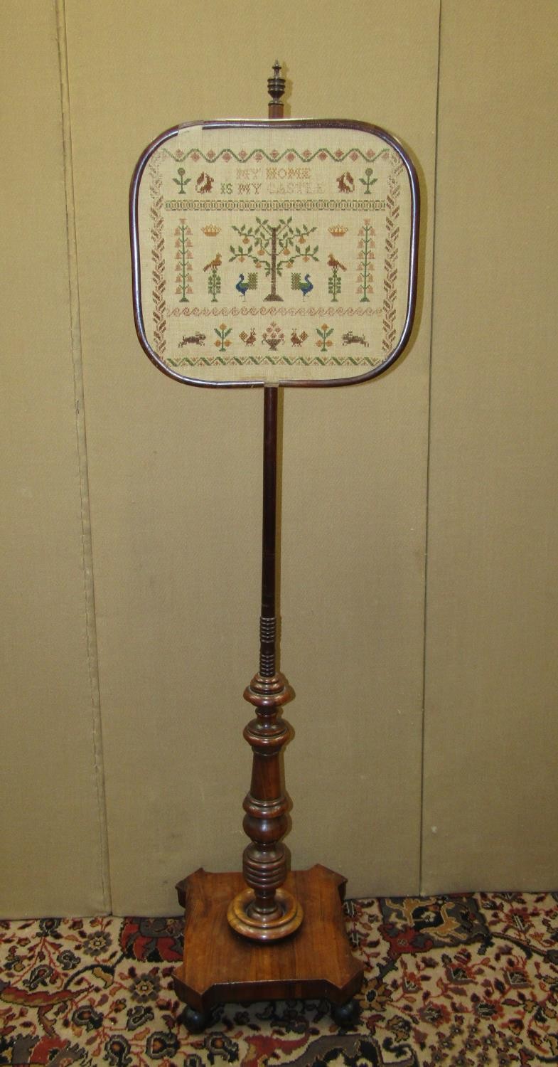 A late Georgian mahogany pole screen on turned column and platform base with tapestry panel,