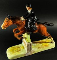 A Beswick equestrian figure group of a woman riding side saddle jumping a fence