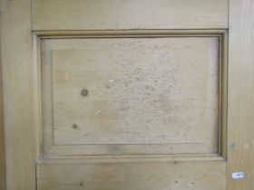 A Georgian stripped and waxed pine freestanding corner cupboard enclosed by two panelled doors