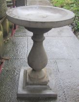 A cast composition stone three section bird bath with circular top raised on a baluster pedestal and