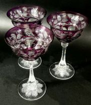 Three coloured cut glasses and three coloured hock glasses and a claret jug and a wine coaster