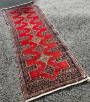 North West Persian Senneh Runner with nine interlocking stepped medallions on a red ground, 255 x