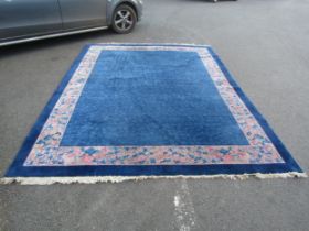 A Large blue ground Chinese rug, with a pink floral patterned border, 360cm x 280cm approx.