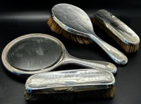 An assortment of six silver backed brushes and a single silver hand mirror (7)