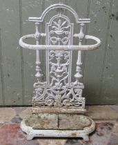 A small painted cast iron umbrella stand with decorative pierced foliate back over a removable