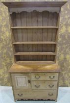 A small Edwardian stripped pine cottage dresser, the base enclosed and fitted with an arrangement of