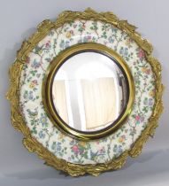 An ormolu mounted convex mirror set in Burslem plate decorated with roses & birds and an outer frame