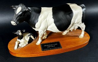 A Beswick porcelain model of a Friesian cow & calf on oval timber base