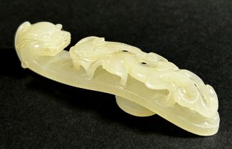 A pale Chinese jade belt hook, decorated with pierced dragon mounts, 8cm long, Qing dynasty or