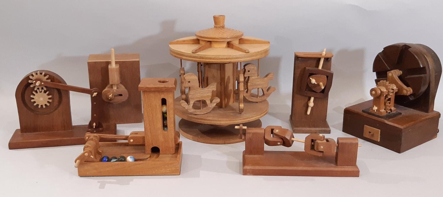 A collection of scratch- built wooden toys and models including a moving marble toy with crank
