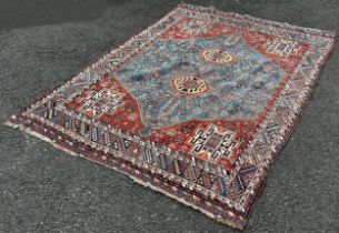A Heriz Persian carpet with a central medallion with two interlocking lozenge with a red surround