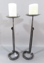 A pair of hand forged iron candlesticks, 43cm high.