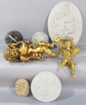 A decorative gilt putti figure, a plaster putti wall plaque, a trumpet blowing winged cherub,