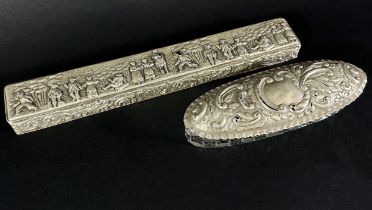 A long narrow silver fan box with an embossed engraved rustic scene to the lid and a glass trinket