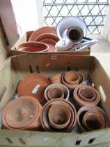 Two boxes of weathered terracotta flowerpots of varying size together with a few enamel items