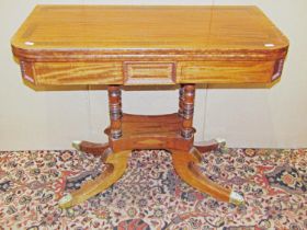 A Regency D end foldover card table raised on four turned columns with platform and four sabre