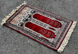 A small silk prayer mat, a small Bokhara rug with a single row of guls, a small Bokhara with two