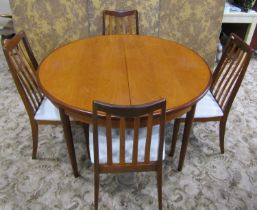 A G-plan teak circular extending dining table with single additional leaf raised on turned tapered