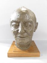 A bronzed resin bust of Arthur Frith, wearing a crew neck jumper, set on a wooden plinth, 35cm high