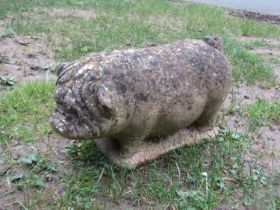 A weathered cast composition stone garden ornament in the form of a Vietnamese potbellied pig, 24 cm