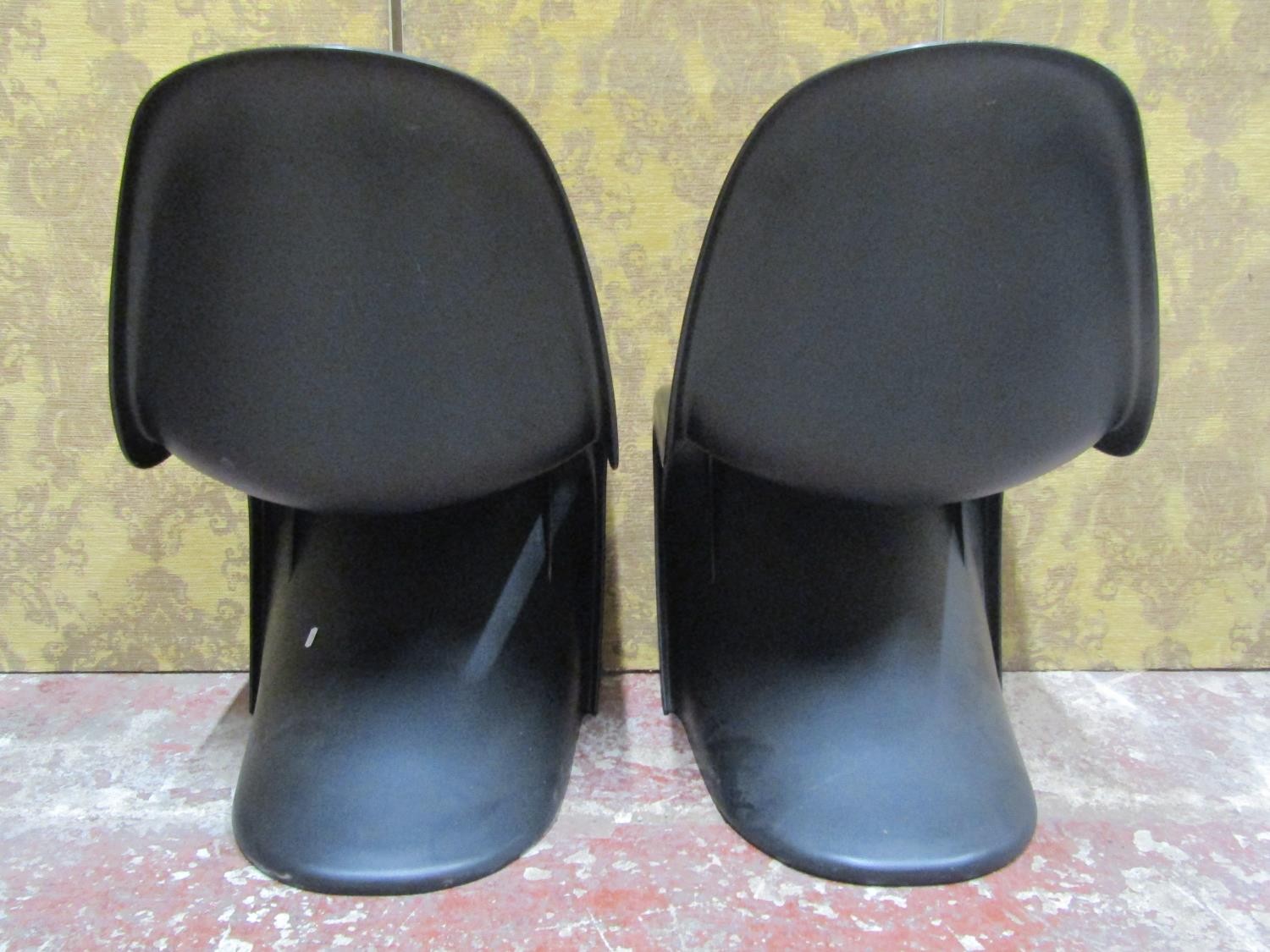 A pair of contemporary moulded plastic cantilever chairs in a black colourway in stacking format - Image 6 of 6