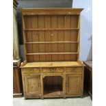 A 19th century stripped and waxed pine cottage dog kennel dresser, the base fitted with three frieze