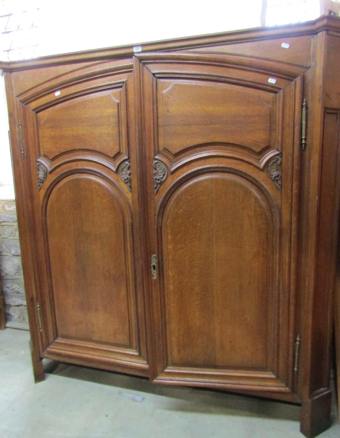A low oak hanging hall wardrobe enclosed by a pair of carved and panelled doors, within a panelled - Image 2 of 3