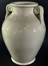 A large cream glazed urn shaped studio ware vase with scroll handles, 32cm high