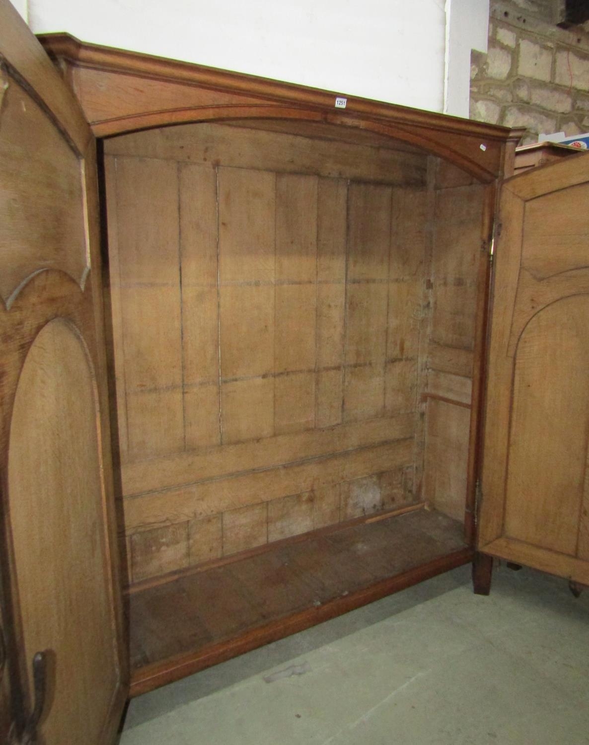 A low oak hanging hall wardrobe enclosed by a pair of carved and panelled doors, within a panelled - Image 3 of 3