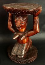 Attributed to the Fakeye group, a large Yoruba / Nigerian carved figural hardwood stool, in the form