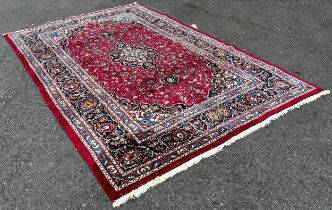 A Kasahan Persian carpet with a central blue medallion in a red surround of flowers, 310cm x 200cm.