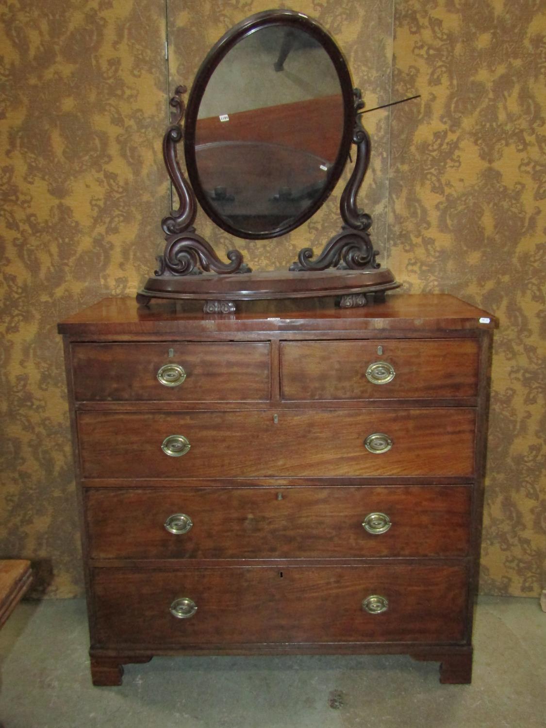 A Georgian mahogany bedroom chest of two short over three long graduated drawers set on bracket