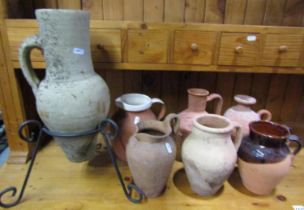 Six small terracotta jugs of varying design together with a weathered Mediterranean example set in a
