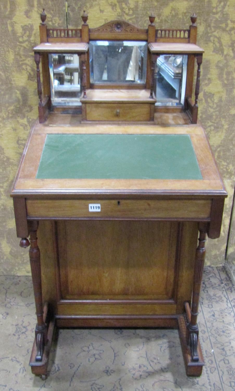 A late Victorian mahogany davenport with raised triple bevelled edge mirror back over the usual