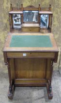A late Victorian mahogany davenport with raised triple bevelled edge mirror back over the usual