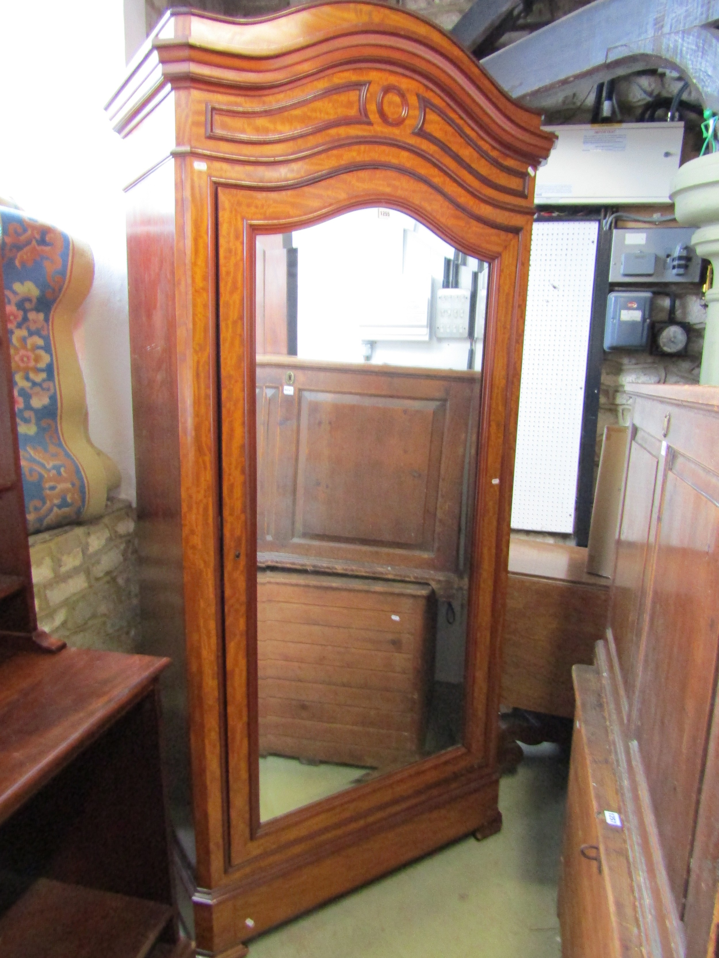 A 19th century mahogany wardrobe with arched outline, enclosed by a mirror panel door, 225cm high